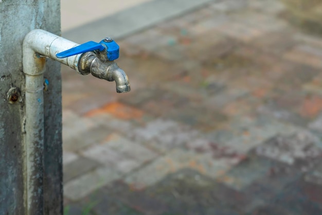 Oude kleptapkraan van blauw pijpwater