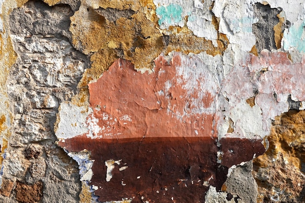 Oude kleurrijke schraperige ongelijke beschadigde muur geschilderde oppervlakte als achtergrond front view abstracte foto