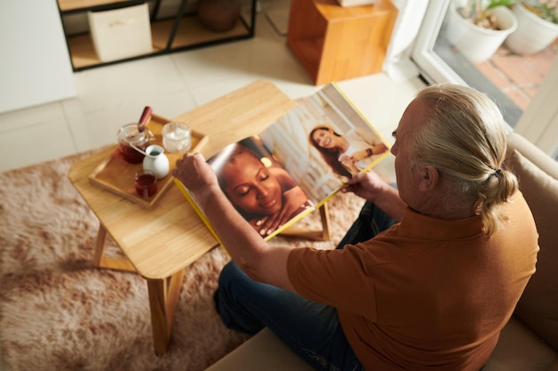 Oude man die naar foto's kijkt