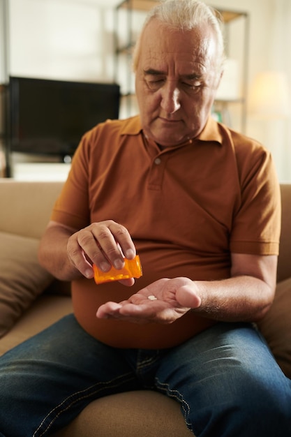 Oude man die tabletten neemt