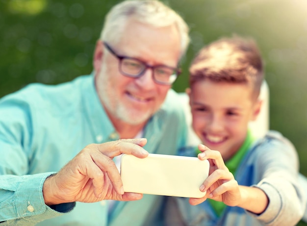 Foto oude man en jongen nemen een selfie met hun smartphone.