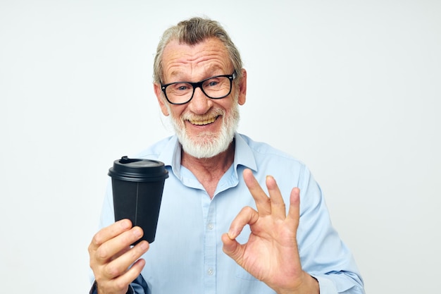 Oude man gebaren met zijn handen een glas drank geïsoleerde achtergrond