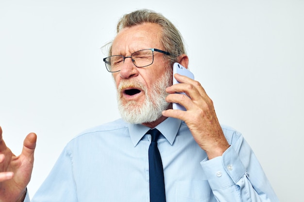 Oude man in een overhemd met een stropdas aan de telefoon bijgesneden weergave
