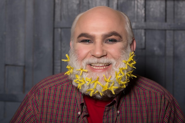 Oude man met bloemen in baard