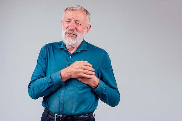 Oude man met borst vanwege hartinfarct in studio witte background.loss van een geliefde concept.