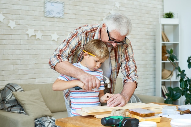 Foto oude man onderwijs jongen timmerwerk