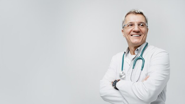 Oude mannelijke dokter laat lachend in uniform zien
