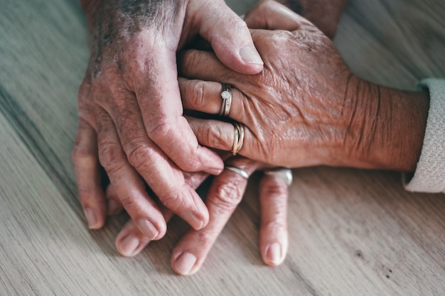 Oude mensen hand in hand close-up bekijken senior gepensioneerd gezin paar uitdrukkelijke zorg als ondersteuning