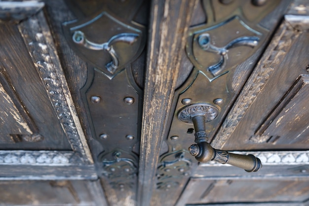 Oude metalen deurklink op de oude deur.