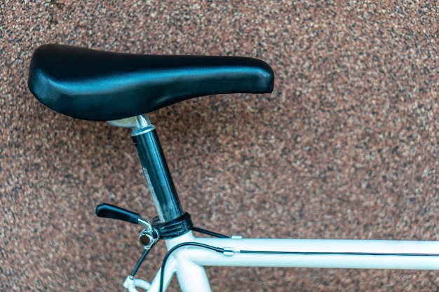 Oude mountainbike die bij de muur staat Reparatie van retro fietsen Wit metalen frame Zwart zadel close-up Soft focus