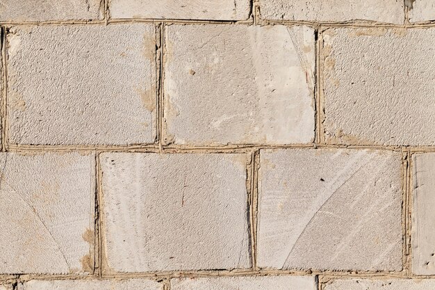 Oude muur van een gebouw gemaakt van grote silicaatblokken, close-up