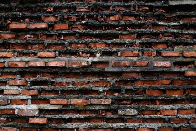 Oude muur van gebroken bakstenen, muur van een ingestort gebouw. Horizontaal buitenschot.