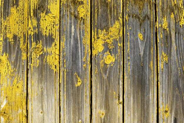 Oude natuurlijke verweerde houten planken met gebarsten gele verfachtergrond