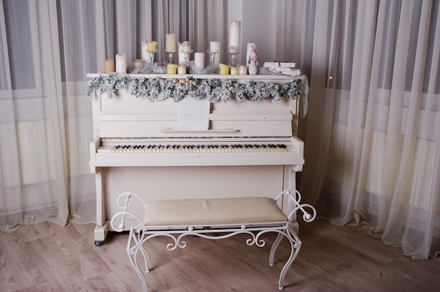 Oude piano met nieuwjaarsversieringen, kaarsen.