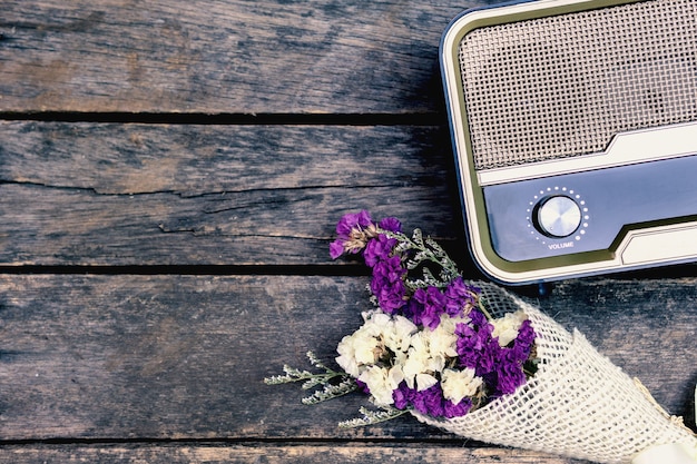 Oude retro radio is gepaard met gedroogde bloemen op oude houten vloer