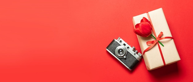 Oude retro vintage camera, geschenkdoos met rood lint op rood