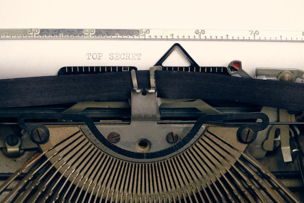 Oude retro vintage typemachine. Een wit vel met de bedrukte tekst topgeheim.
