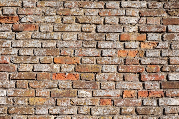 Oude rode bakstenen muur in natuurlijk licht.