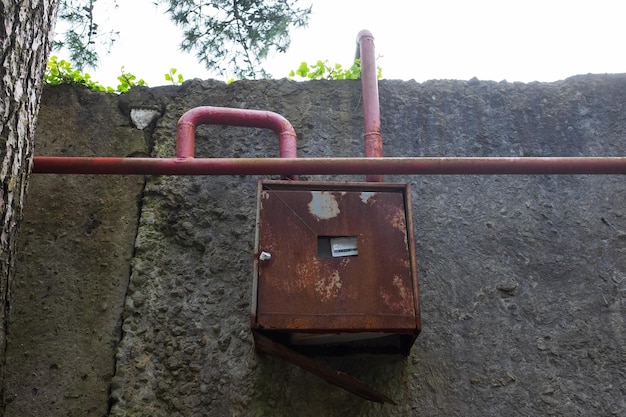 Oude rode pijpen en gasmeter op muur