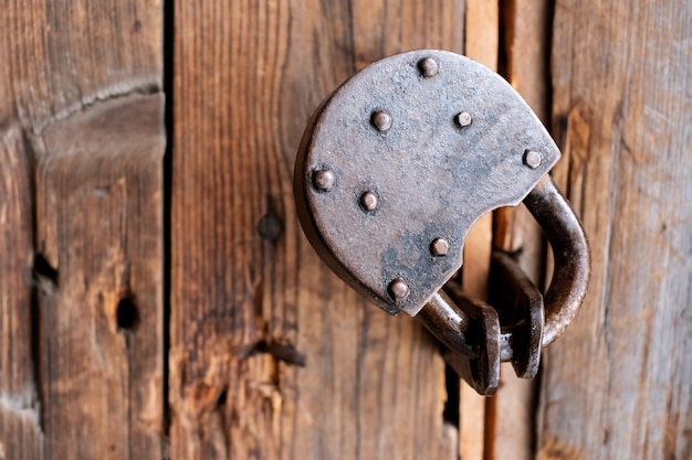 Oude roestige hangslotclose-up op een houten deur