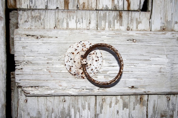 Oude roestige ijzeren ring op een houten ondergrond.