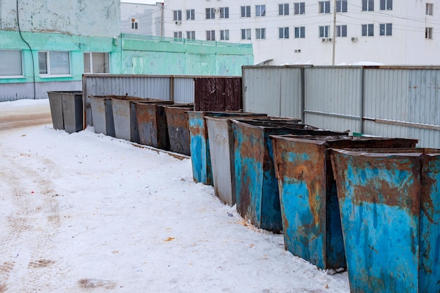 Oude roestige vuilnisbakken in de winter. Rusland