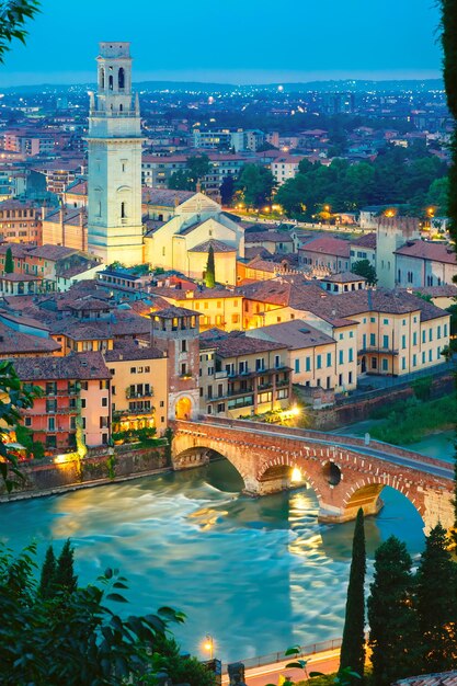 Oude Romeinse brug Ponte Pietra op de rivier de Adige en de kathedraal Duomo van Verona bij nachtverlichting, uitzicht vanaf Piazzale Castel San Pietro, Verona, Italië