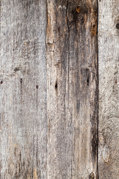 Oude rottende houten planken, onderdeel van de muur van het gebouw in het dorp