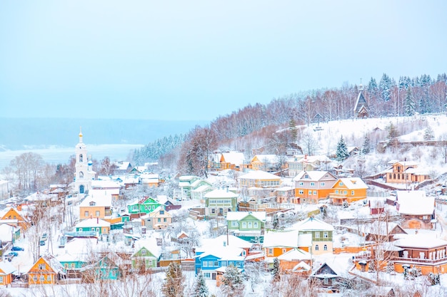 Foto oude russische stad ples met oude houten kleurrijke huizen aan de wolga in de winter met sneeuw ivanovo regio rusland