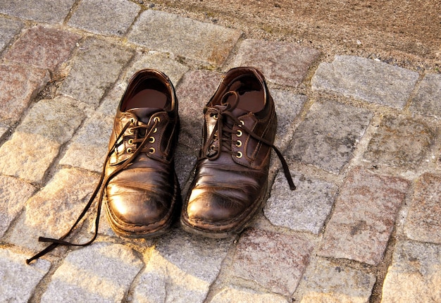 Oude schoenen op de geplaveide stoep