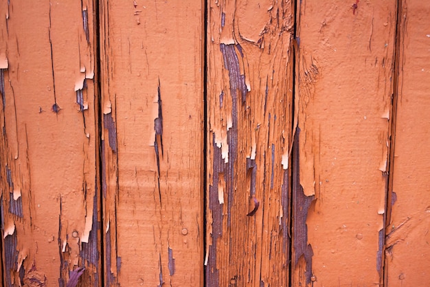 Oude sjofele muur, planken in natuurlijke scheuren en reliëfs, oude afbladderende verf op de planken. Grunge achtergrond