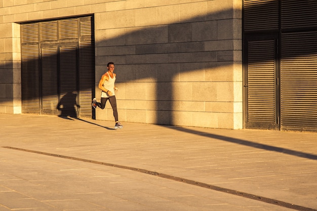 Oude sportman die op landweg loopt