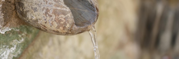 Oude steen en fontein met bronwater dat in het zwembad stroomt