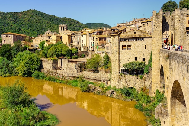 Oude stenen huizen aan de rivier en reflectie in het water Besalu Gerona Spain