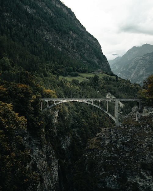 Foto oude stenen humeurige brug in zwitserland met bergen erachter