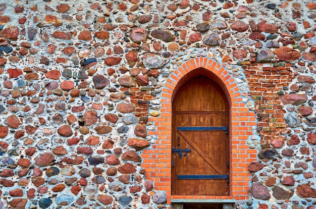 Oude stenen muur met houten deur