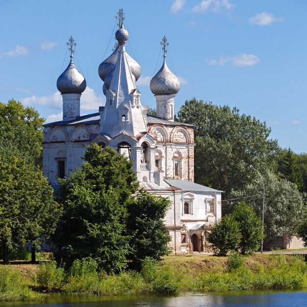 Oude stenen orthodoxe kerk aan de oevers van de rivier in Rusland