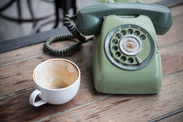 Foto oude telefoon en koffie kop na het drinken