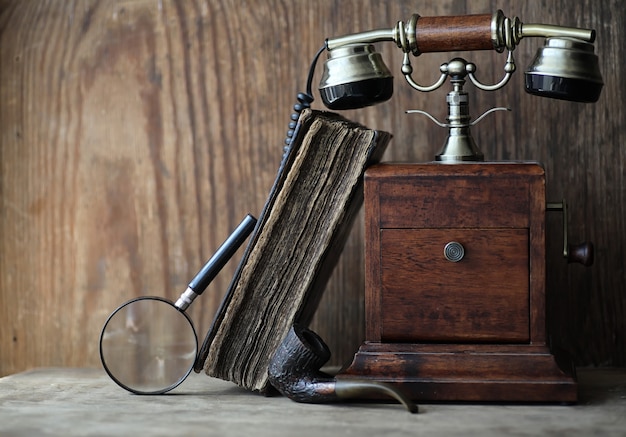 Oude telefoon en retro boek op een houten tafel