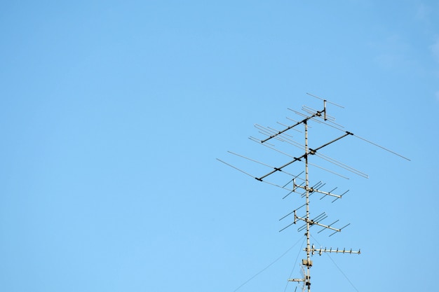 Oude televisiesantenne op blauwe hemel