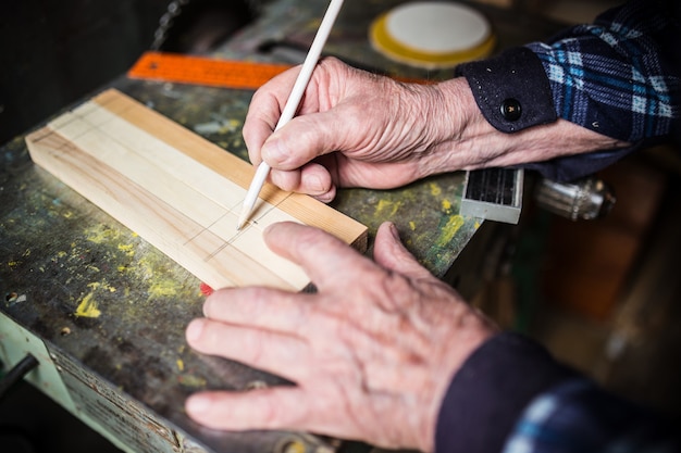 Oude timmerman meten van een houten plank wooden