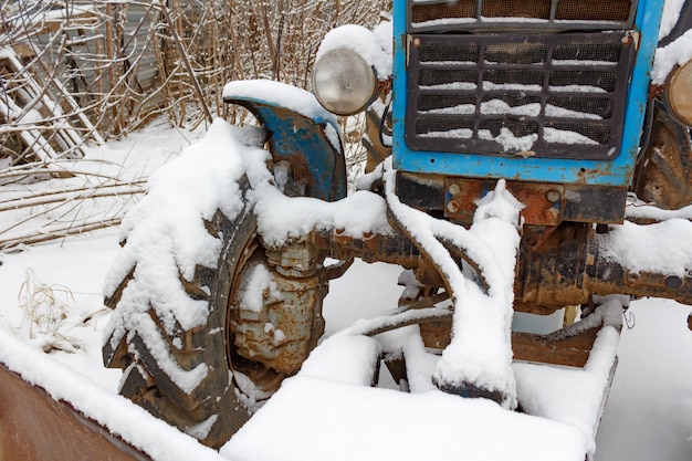 Oude tractor bedekt met sneeuw