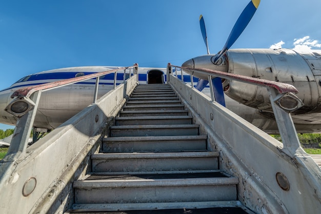 Oude, versleten passagiersgang. Gangway vastgemaakt aan het vliegtuig.