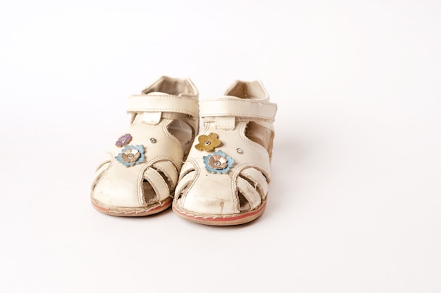 Oude vintage babysandalen op wit