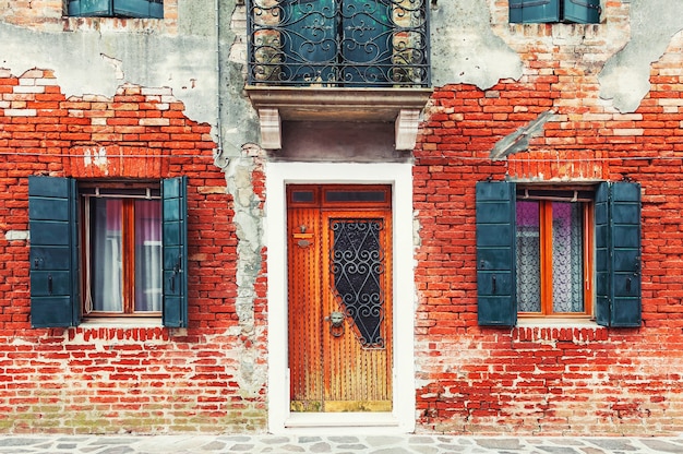 Oude vintage bakstenen gevel van het huis met deur en ramen. Middeleeuwse architectuur in Venetië, Italië.