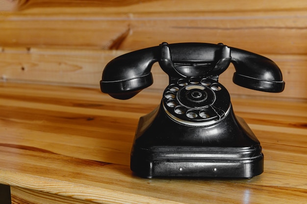 Oude vintage zwarte telefoon op houten tafel.