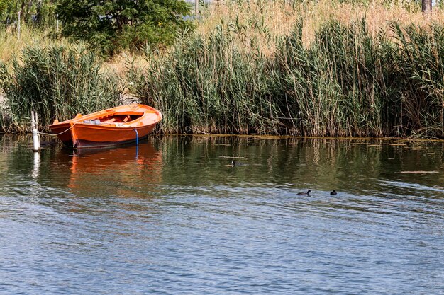 Oude vissersboot afgemeerd aan de oever van het meer op een zonnige zomerdag