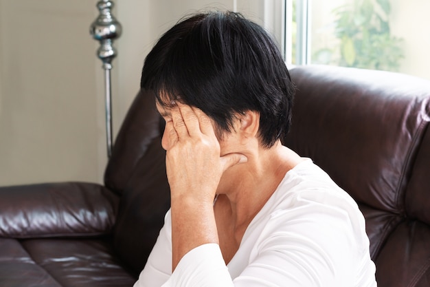 Oude vrouw die aan hoofdpijn, spanning, migraine, het concept van het gezondheidsprobleem lijden