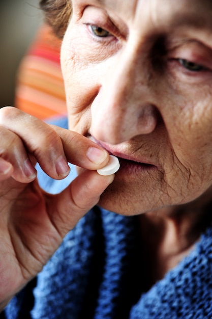 Oude vrouw die pil neemt