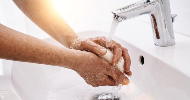 Oude vrouw die zijn handen wast om virusinfectie te voorkomen en vuile handen schoon te maken corona covid19 concept afbeelding